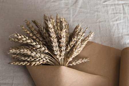 Making a bouquet of ears of oats on the background of kraft paper.の写真素材