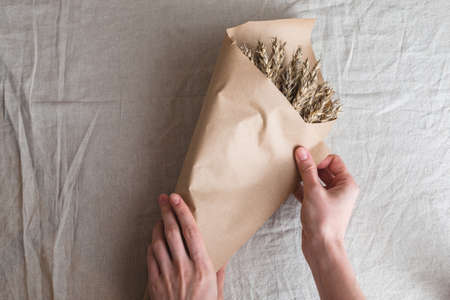 Making a bouquet of ears of oats on the background of  paper.の写真素材