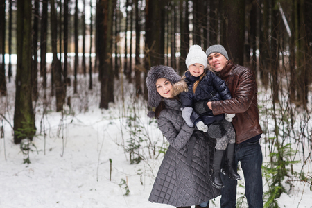 Happy young family walking in the winter park three.の写真素材