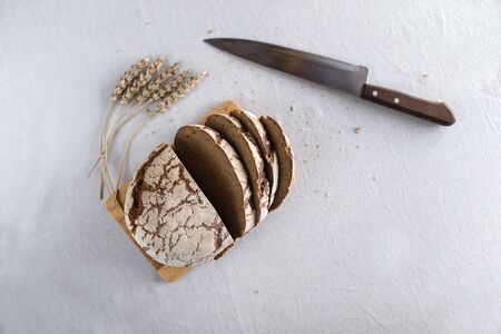 Tasty and delicious sliced loaf of bread on a board. Bread is on a background of linen fabric....