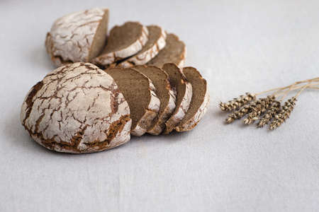 Tasty and delicious sliced loaf of bread on a board. Bread is on a background of linen fabric.