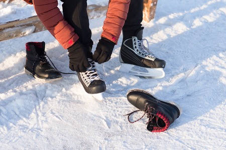 The man wears a winter skates at the rink. Humans disguises shoes on skates.の写真素材