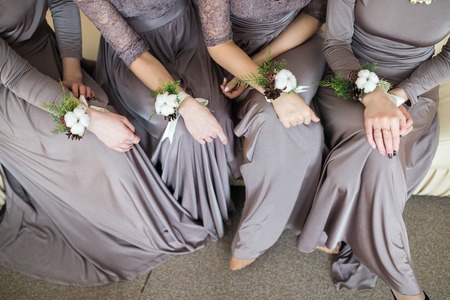 bridesmaids with wedding bouquet of flowers at  bridal ceremony. bridesmaids with boutonniere buttonhole at wedding day. bride friends with marriage flowers wedding. woman with wedding hands flowersの写真素材