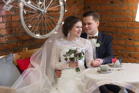 Bride and groom drinking coffee at an outdoor cafeの写真素材