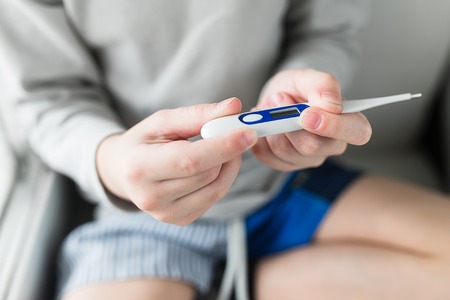 Child boy with thermometer measures temperature.の写真素材