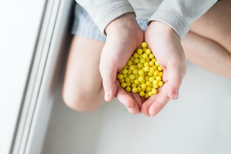 Drops of ascorbic acid in an open handの写真素材