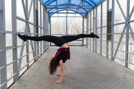 Beautiful young sports woman doing stretching outdoors in transition.の写真素材