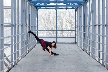 Beautiful young sports woman doing stretching outdoors in transition.の写真素材