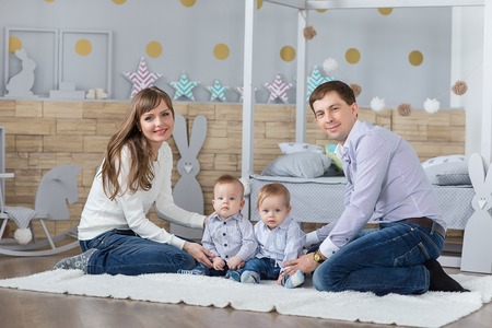 Family portrait of happy mom dad and twins boys having fun timeの写真素材