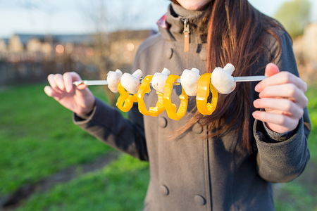 beautiful young woman holding skewers of fresh vegetables for vegansの写真素材