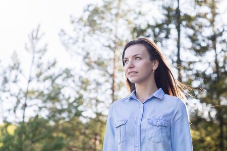 Young attractive female relaxing in nature on beautiful summer day.