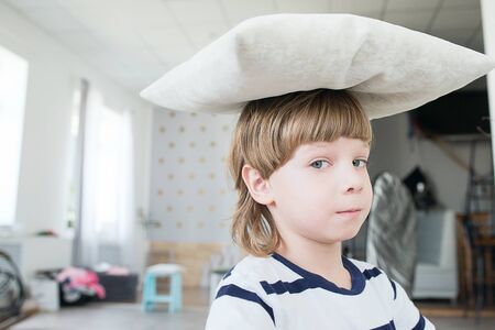Boy playing on the bed with pillows.の写真素材