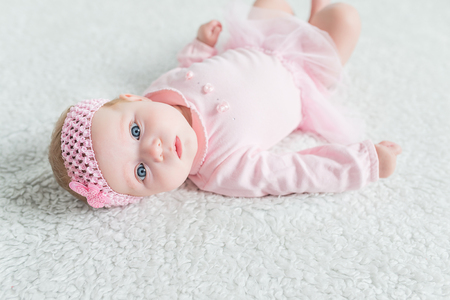 Tiny baby lies on his back on the floor and looking up.の写真素材