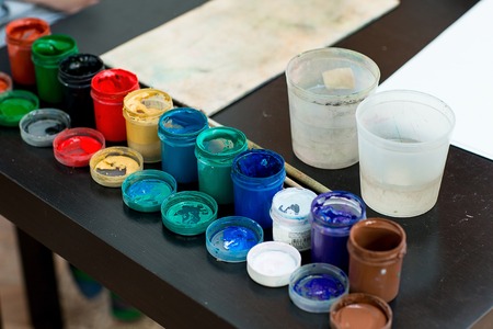 Paints and brushes are on the table on the palette. Workplace artist lover or child.の写真素材