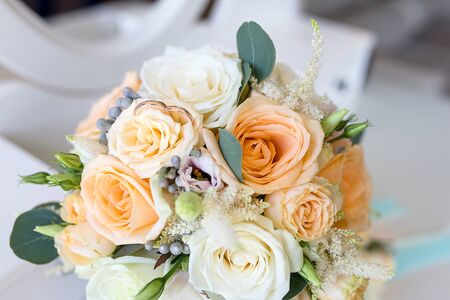 Wedding rings lie on the Bridal bouquet of roses. Gold wedding rings luxaryの写真素材