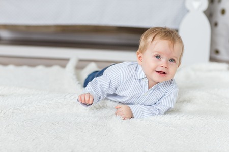 Portrait of a crawling baby on the carpet in his room