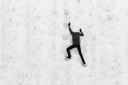 Person child climbs up the icy rock. Child climbing frozen waterfallの写真素材