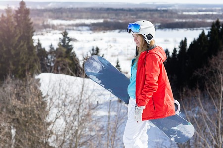 Woman snowboarder on the slopes frosty winter day. Beautiful girl on snoborde in the snow.の写真素材
