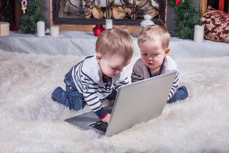 Two cute children using laptop at Christmas Time.の写真素材
