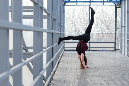 Beautiful young sports woman doing stretching outdoors in transition. The girl is engaged in fitness outdoors.の写真素材