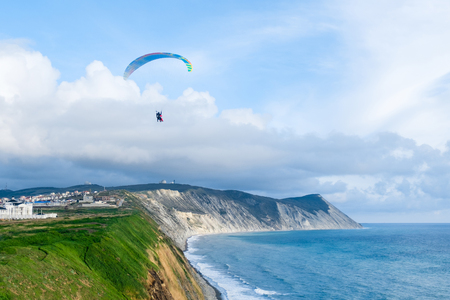 Flying tandem paragliders over the sea and near the mountains, beautiful landscape viewの写真素材