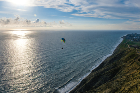 Flying tandem paragliders over the sea and near the mountains, beautiful landscape viewの写真素材