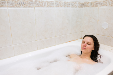 young beautiful girl in a bath with foamの写真素材