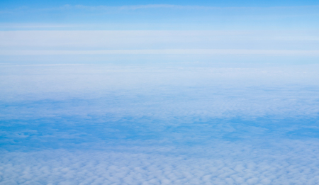 above view many little clouds in blue sky from airplaneの写真素材