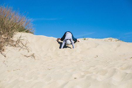 kid playing with sand in the beachの写真素材