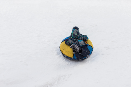 Happy child walks with tubing in the winter frosty dayの写真素材