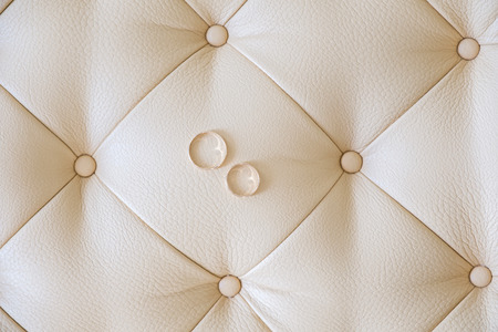 Wedding rings on a light leather sofa. Top view.の写真素材