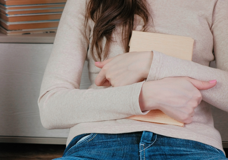 Close-up of the womans hands hugging the book.の写真素材