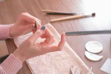 Woman filings nails nail file. Close-up hands. Tools on the table.の写真素材