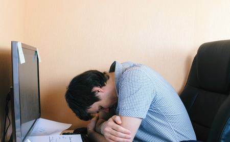 Tired sleepy man sleep at computer.の写真素材