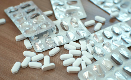 Blisters of pills and white pills on the table. Closeup.の写真素材