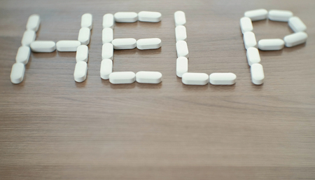 word - help consists of pills on the table.の写真素材
