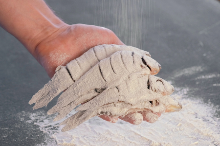Fish in flour in mens hand. Cooking fish. Hands close up.の写真素材