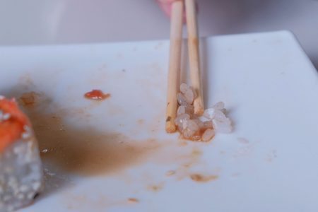 Woman eats rolls with chopsticks. Hand close-up.の写真素材