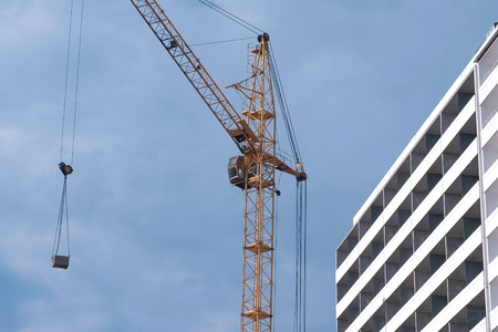 Construction of a multi-storey building. House and construction crane on sky background.の写真素材
