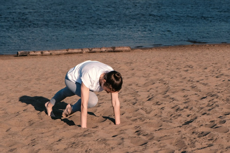 Woman doing the exercises sports on the banks of the river in the city. Plank exercise.の写真素材