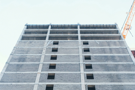 Multi-storey under construction building and construction crane. Close-up view.の写真素材