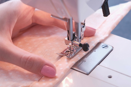 Woman sewing detail on the sewing machine. Close-up hand.の写真素材