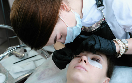 Beautician separates the lashes with a needle.
