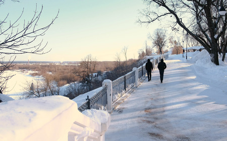 Two guys wearing in black walking in winter park. Back view.の写真素材
