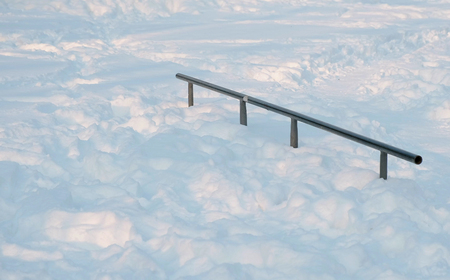 Skate boarding park in snowy winter city Park. Snow drifts on the hill to skateboard.の写真素材