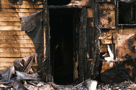Burned down private wooden house outdoor park.の写真素材