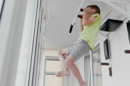 Boy pulled up on the simulator at home on the balcony.の写真素材