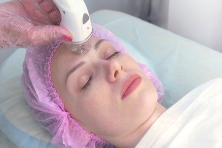 Lymphatic drainage massage LPG apparatus process for face. Therapist beautician makes a rejuvenating...