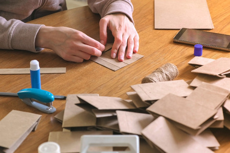 Woman makes a bag for christmas advent calendar from kraft paper.の写真素材