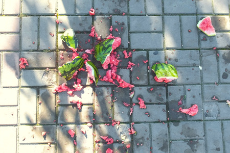 Juicy smashed watermelon broken on paving slabs. Pieces of watermelon on the land.の写真素材